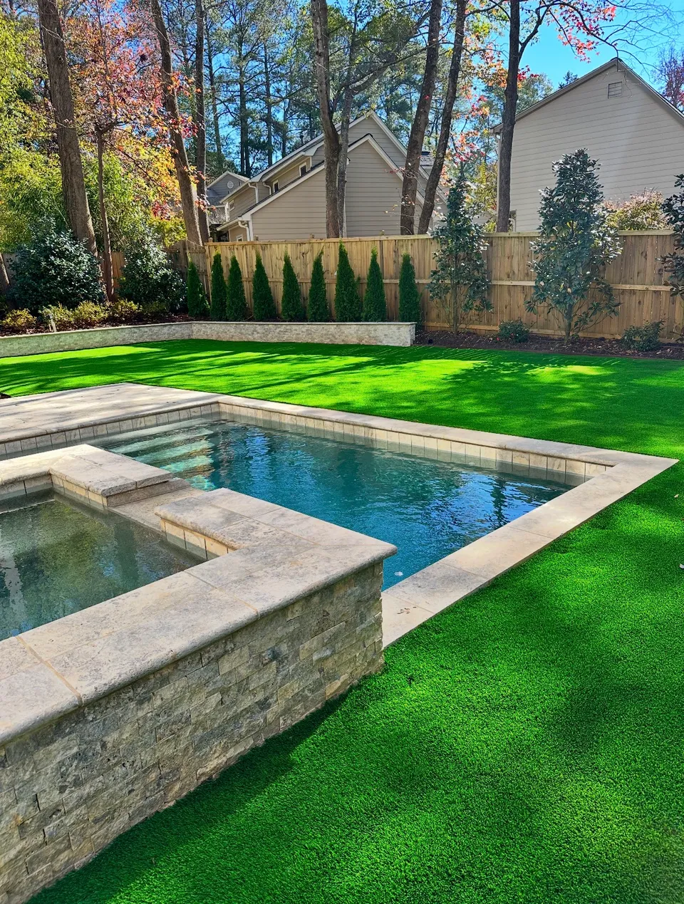 Artificial turf and landscape beds around a pool area